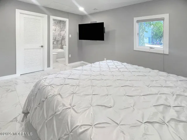 a bedroom with a bed and a flat screen tv