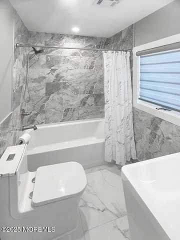 a bathroom with a bathtub a toilet and a shower