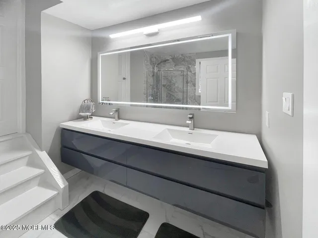 a en suite bathroom with a double vanity sink and a mirror