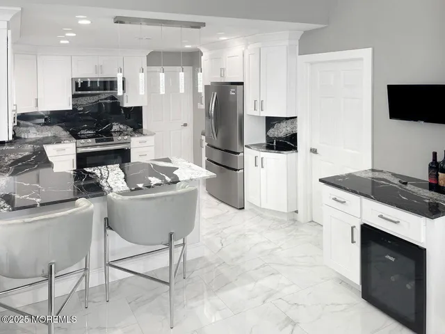 a kitchen with stainless steel appliances granite countertop a stove refrigerator sink and microwave