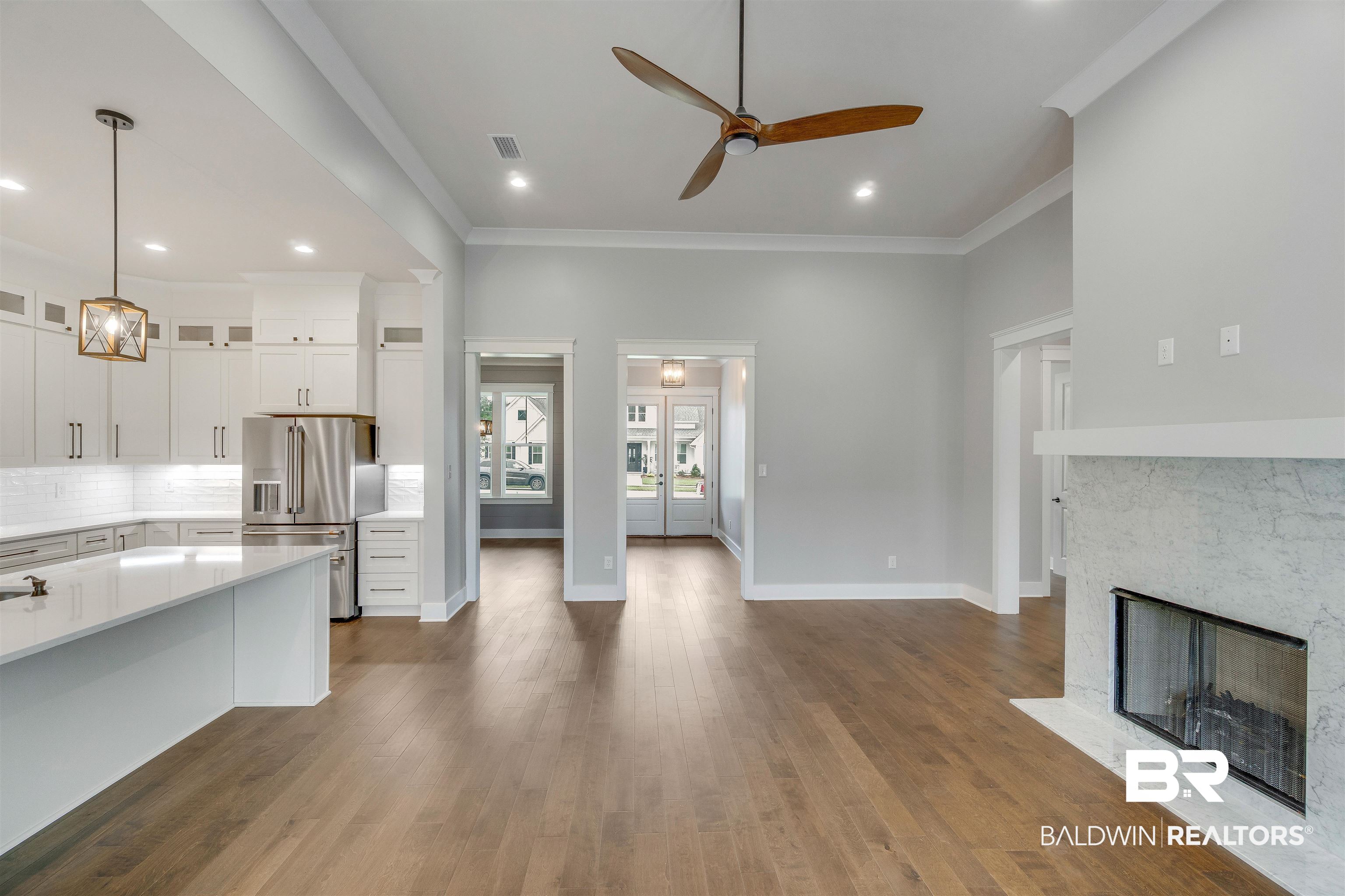 10985 Atrium Avenue Fairhope, AL 36532 - Photo 13 of 58 Kitchen featuring backsplash, high end fridge, a fireplace, glass insert cabinets, and white cabinetry