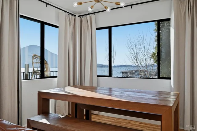 a kitchen with stainless steel appliances a dining table chairs refrigerator and microwave