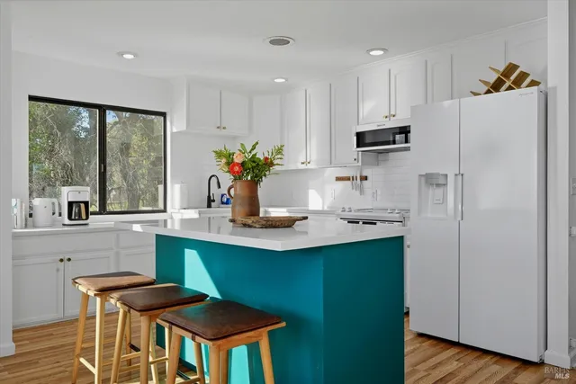 a kitchen that has a lot of cabinets and wooden floor