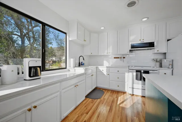 a kitchen with stainless steel appliances white cabinets and a sink