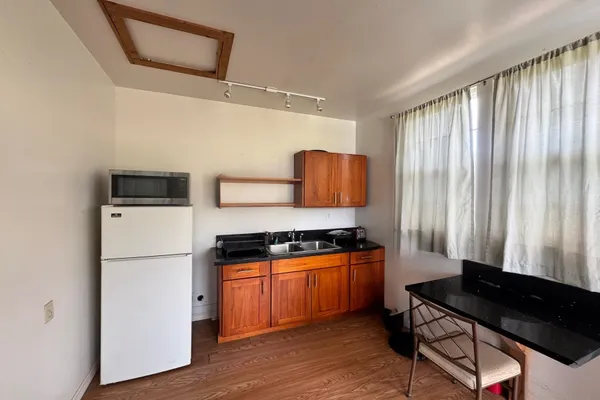 a kitchen with a refrigerator a stove a sink and a dishwasher with wooden floor