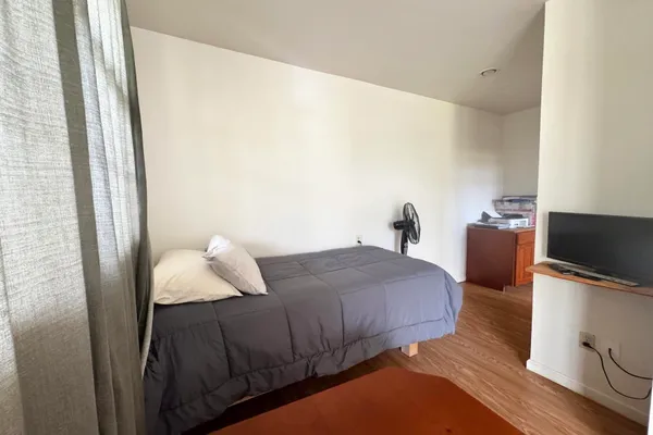 a bedroom with a bed and a flat screen tv