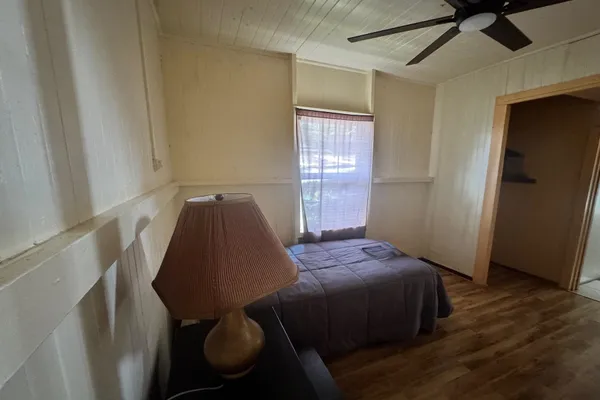 a bedroom with a bed and wooden floor