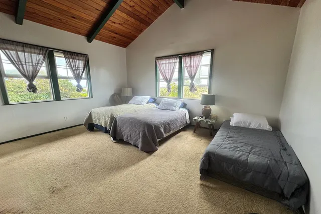 a bedroom with two beds and a large window
