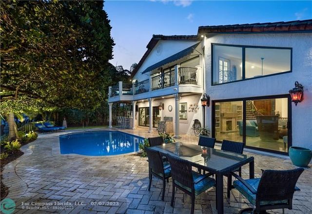 a view of a house with a wooden deck and furniture