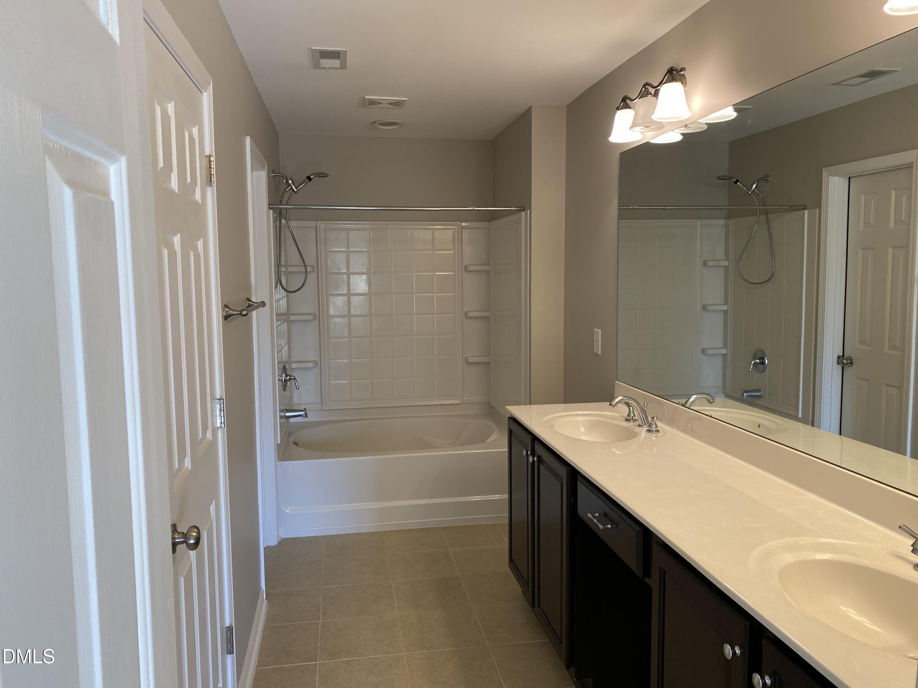 975 Branch Line Lane Apex, NC 27502 - Photo 5 of 12 a bathroom with a sink double vanity mirror and a bathtub