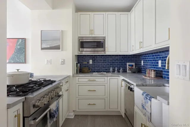 a kitchen with granite countertop a sink stove and cabinets