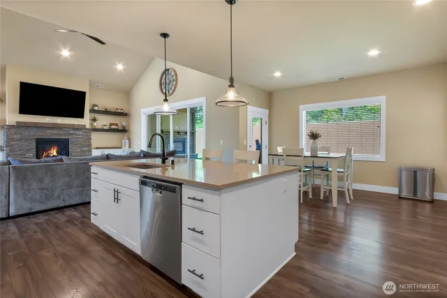 a kitchen with stainless steel appliances granite countertop a sink a stove top oven a counter space and cabinets