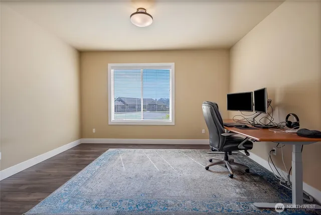 a view of a workspace with furniture and a window