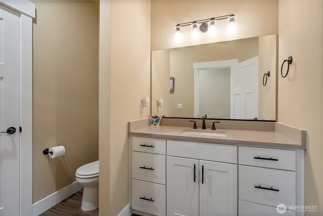 a bathroom with a toilet a sink and mirror
