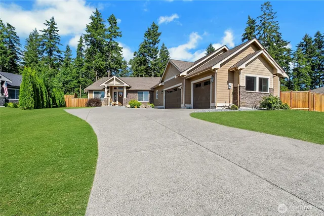 a front view of a house with a yard and trees