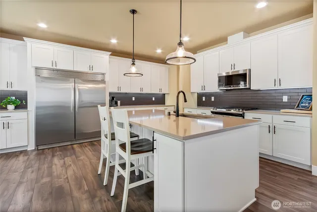a kitchen with kitchen island a counter space a sink appliances and cabinets