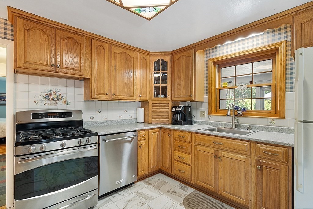 86 Locke Road Chelmsford, MA 01824 - Photo 23 of 41 a kitchen with granite countertop stainless steel appliances a stove sink and cabinets