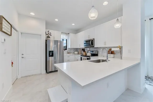 a kitchen with granite countertop white cabinets and stainless steel appliances