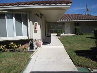 1911 Northeast 27th Court, Unit 13 Lighthouse Point, FL 33064 - Photo 6 of 61 a front view of a house with a yard