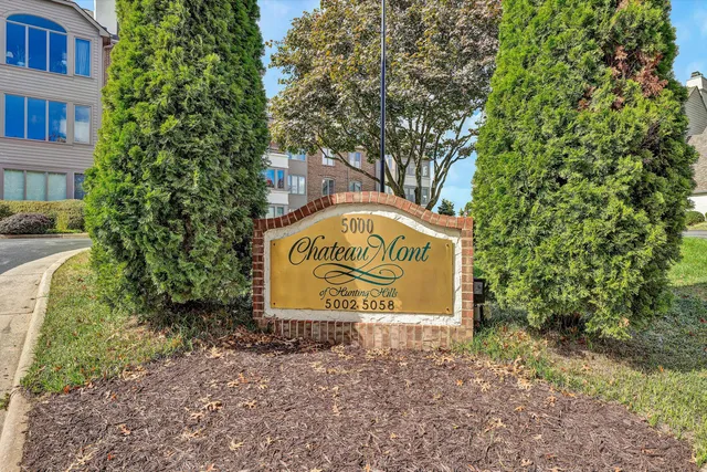 a kitchen with stainless steel appliances a stove a refrigerator a sink a dining table and chairs