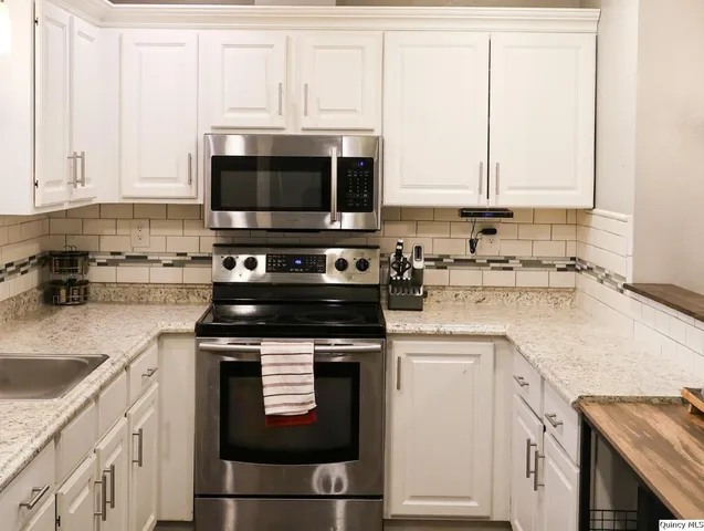 a kitchen with granite countertop a sink and a stove