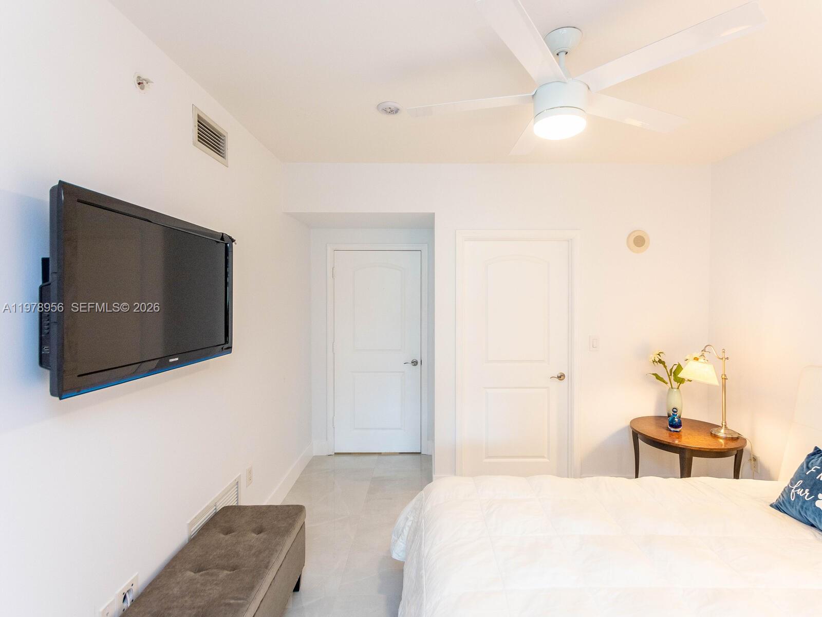 7350 Southwest 89th Street, Unit 719S Miami, FL 33156 - Photo 23 of 30 a bedroom with a bed and a flat screen tv