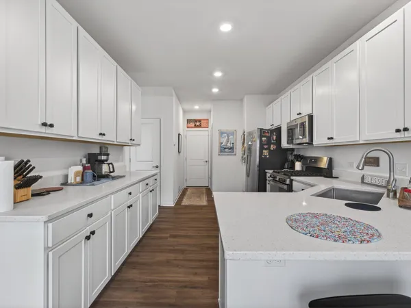 a large kitchen with stainless steel appliances lots of counter space sink refrigerator and cabinets