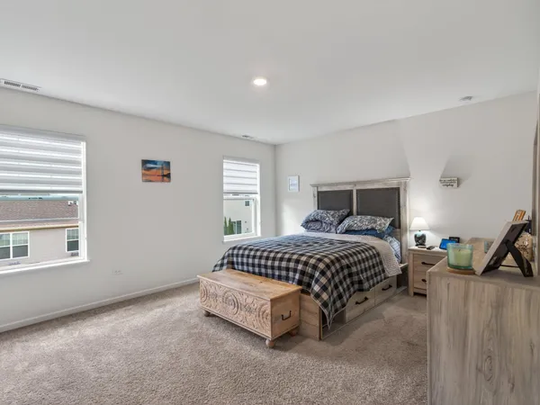 a spacious bedroom with a bed and wooden floor
