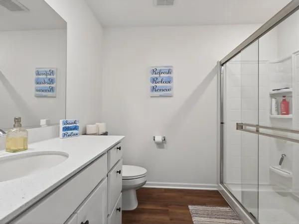 a bathroom with a sink a toilet and shower