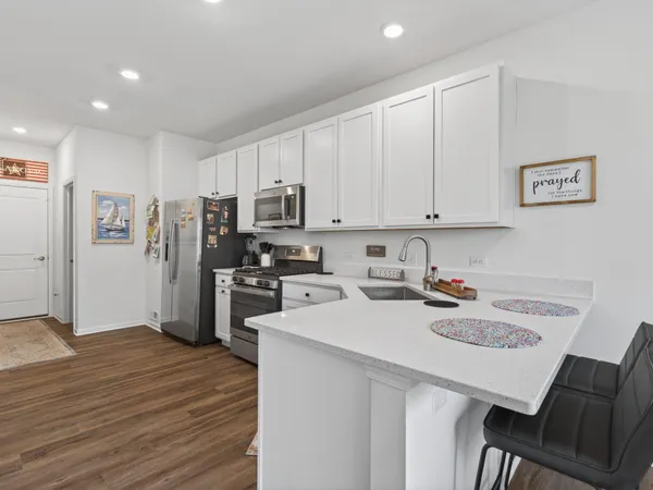 a kitchen with a sink a stove a refrigerator and white cabinets