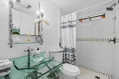 a bathroom with a sink a toilet and shower