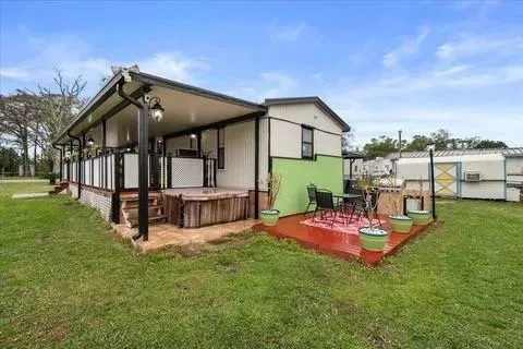 a view of a house with backyard and porch