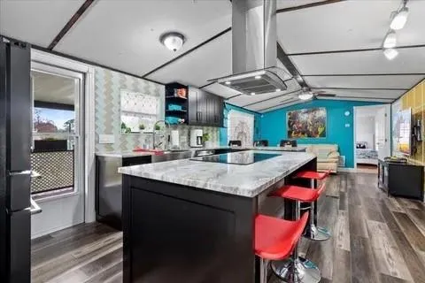 a kitchen with stainless steel appliances granite countertop a sink and wooden floor