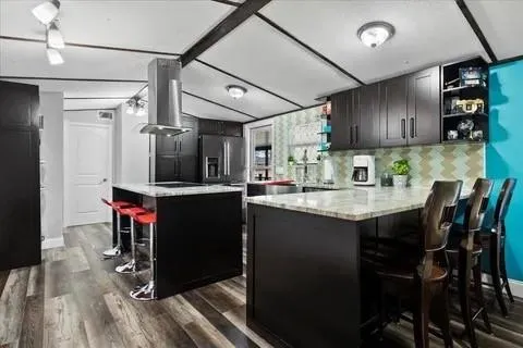 a kitchen with stainless steel appliances granite countertop a sink refrigerator and cabinets