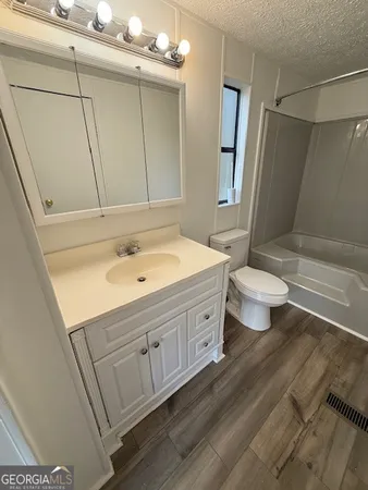 a bathroom with a double vanity sink a toilet and shower