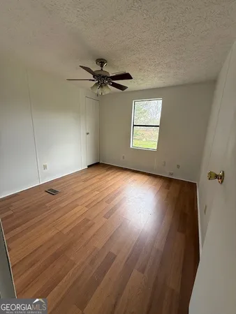 an empty room with a window and a ceiling fan
