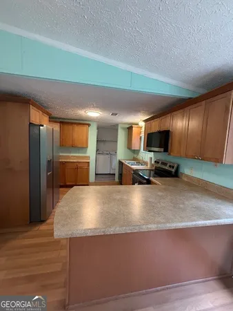a large kitchen with stainless steel appliances and a refrigerator