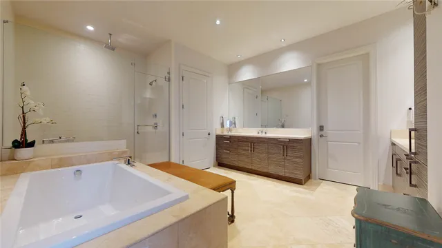 a bathroom with a tub a sink shower and mirror
