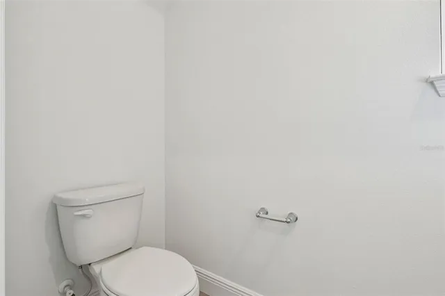 a white toilet sitting next to a white wall