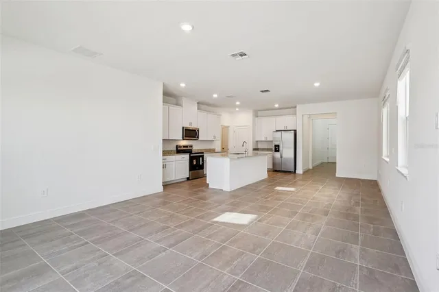 a view of a kitchen with furniture and stainless steel appliances