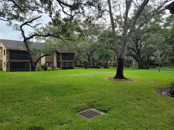 a front view of a house with garden and tree