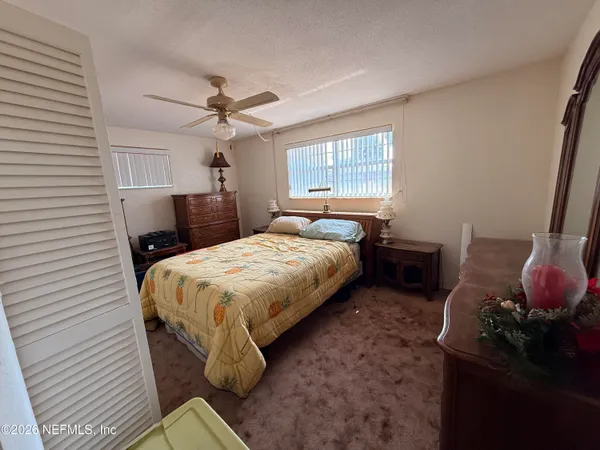 a spacious bedroom with a bed and a chandelier