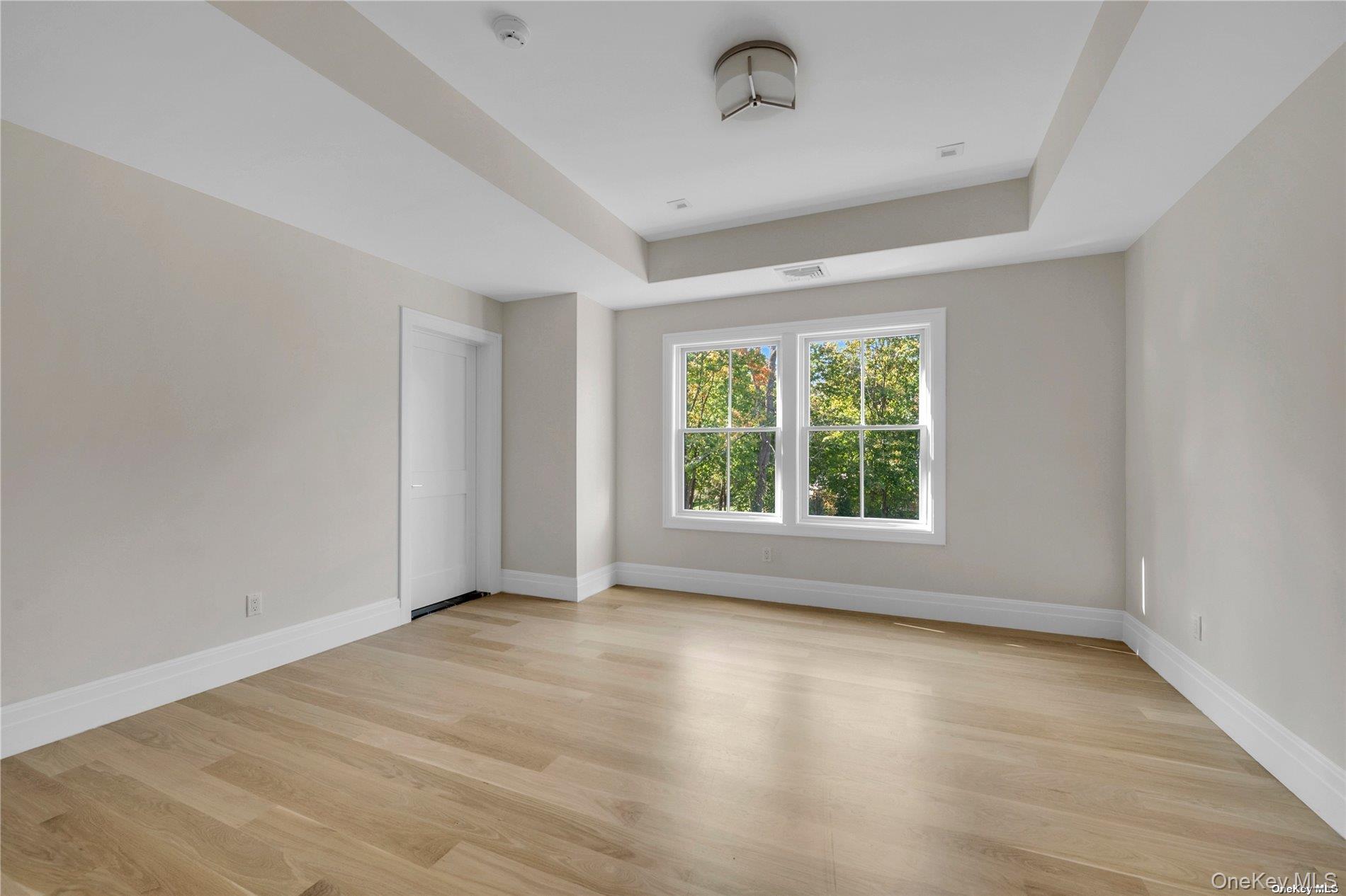38 Cow Neck Road Sands Point, NY 11050 - Photo 23 of 48 an empty room with wooden floor and windows