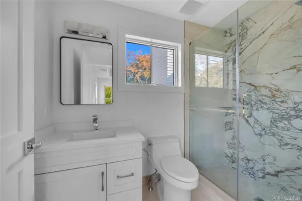 a bathroom with a toilet sink and mirror