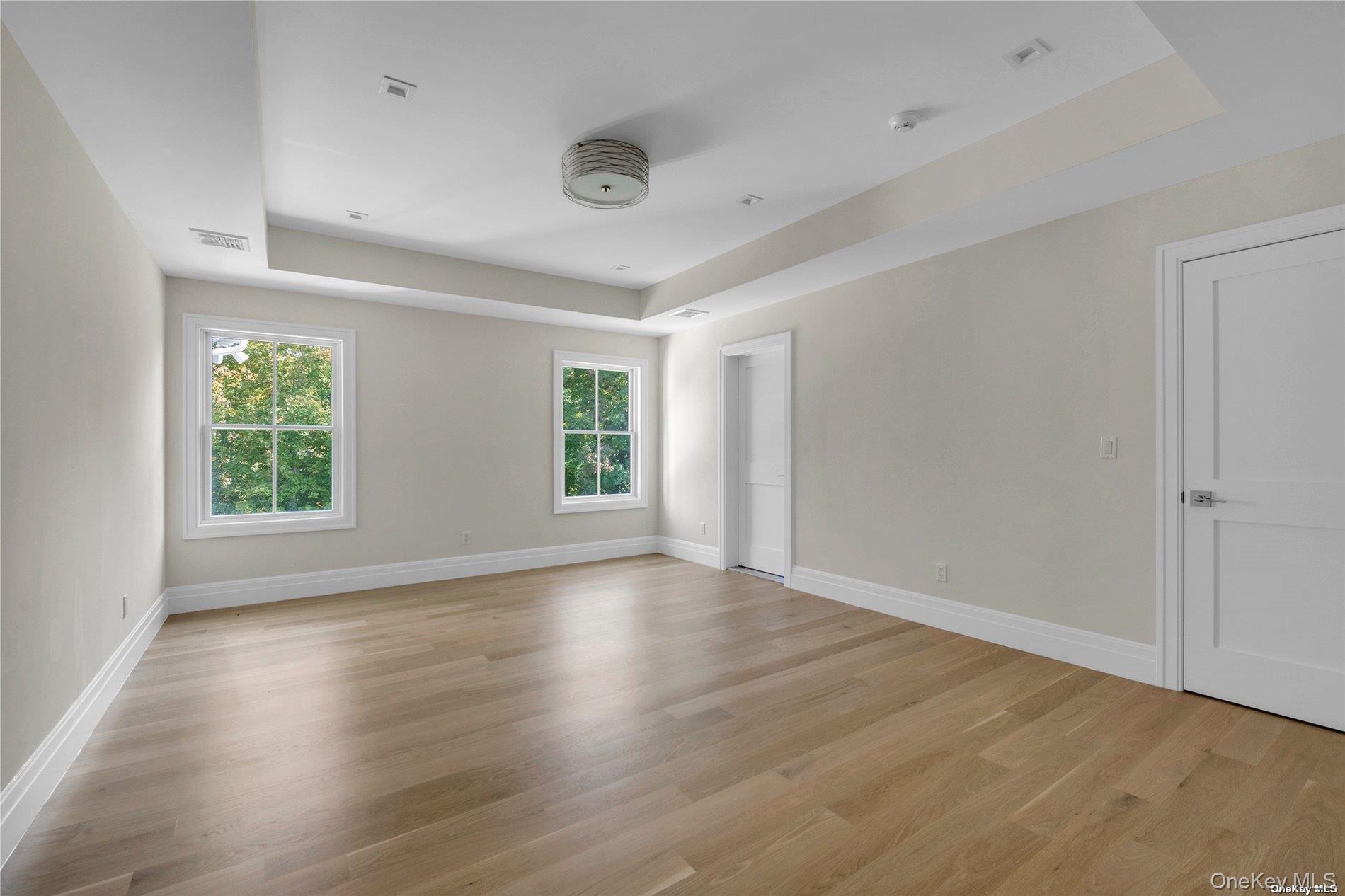 38 Cow Neck Road Sands Point, NY 11050 - Photo 25 of 48 an empty room with wooden floor and windows