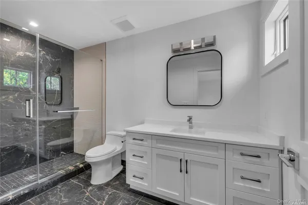 a bathroom with a toilet sink and mirror