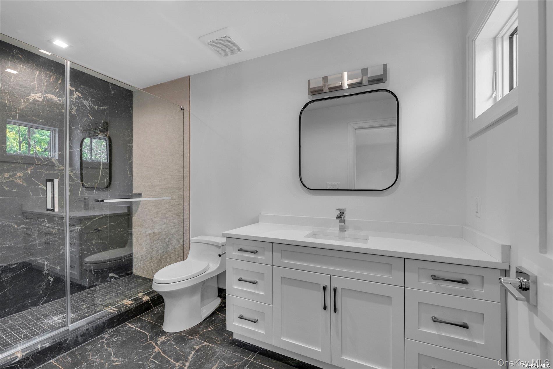 38 Cow Neck Road Sands Point, NY 11050 - Photo 26 of 48 a bathroom with a toilet sink and mirror