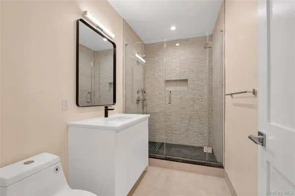 a bathroom with a sink mirror toilet and shower