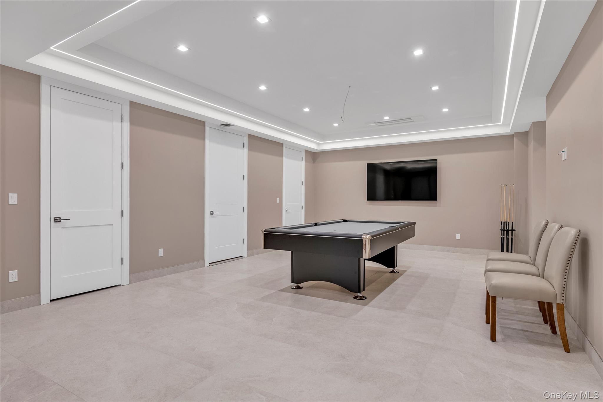 38 Cow Neck Road Sands Point, NY 11050 - Photo 33 of 48 a living room with furniture a flat screen tv and a refrigerator