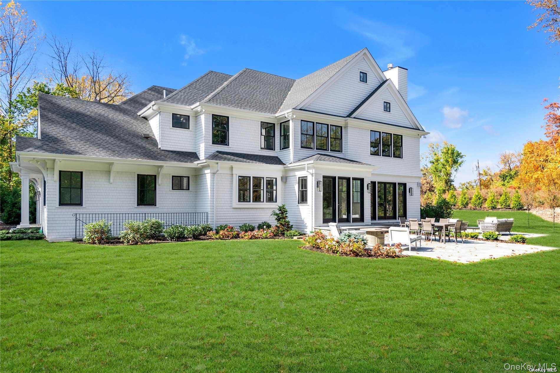 38 Cow Neck Road Sands Point, NY 11050 - Photo 42 of 48 a front view of a house with a yard table and chairs